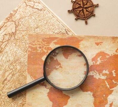 magnifying glass and wind rose on maps